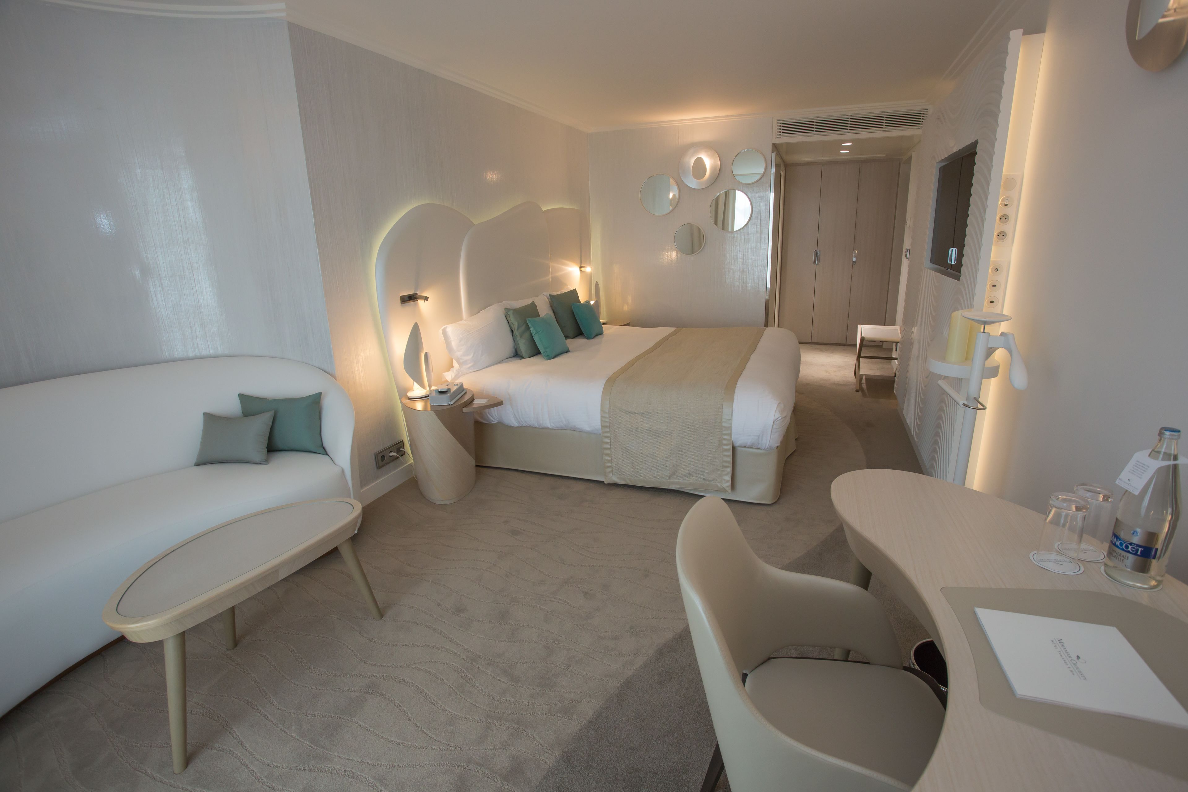 Ein modernes Hotelzimmer mit einem Bett, einer Couch, einem Schreibtisch und einem Sessel.