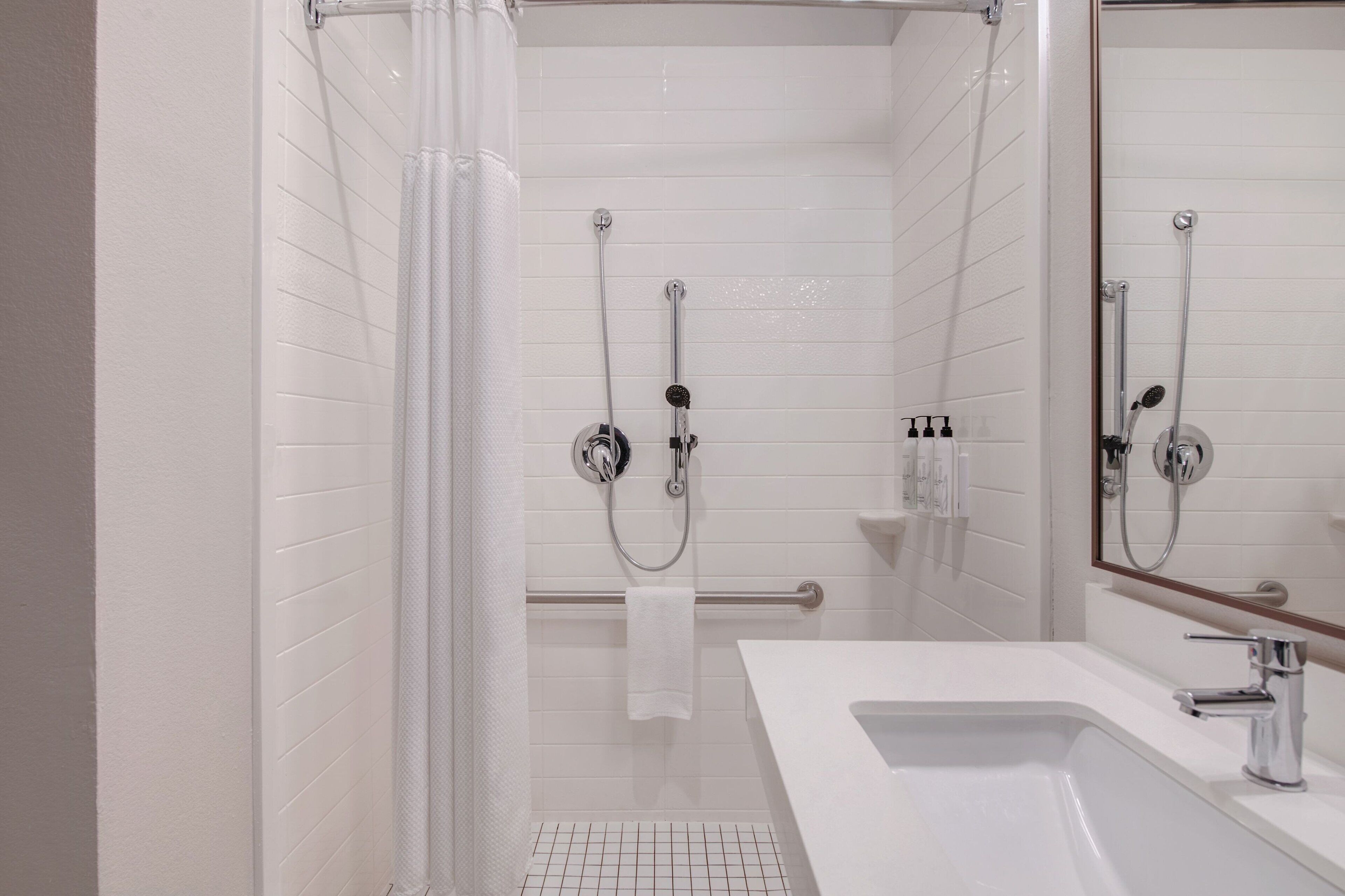 Un baño moderno con ducha, lavabo y espejo.