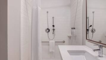 Un baño moderno con ducha, lavabo y espejo.