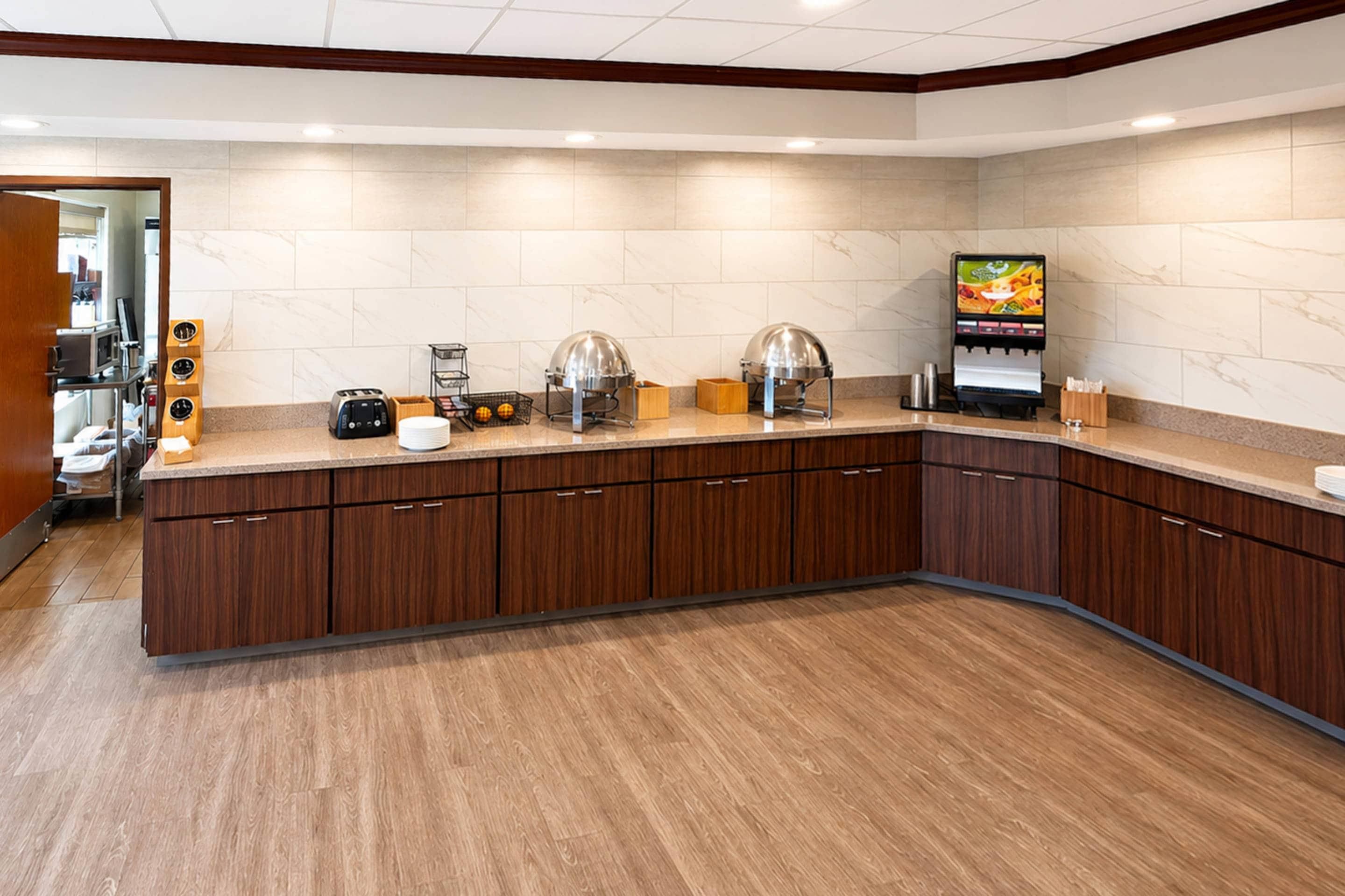A modern kitchen with a marble backsplash, wooden cabinets, and a built-in coffee machine.