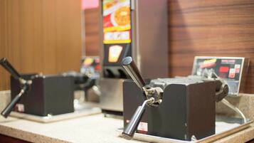 Een koffieapparaat met een digitaal menuscherm op de achtergrond.