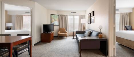 Escritorio, cortinas blackout y tabla de planchar con plancha