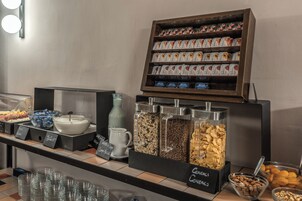Un ricco buffet per la colazione con diverse opzioni tra cui cereali, frutta e bevande.