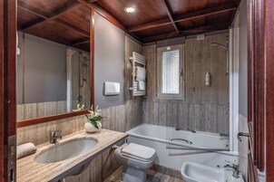 Un bagno con un lavandino grande, un water, una vasca e una doccia.