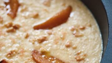 A close-up of a creamy dish in a cast iron skillet with visible chunks of meat and caramelized onions.