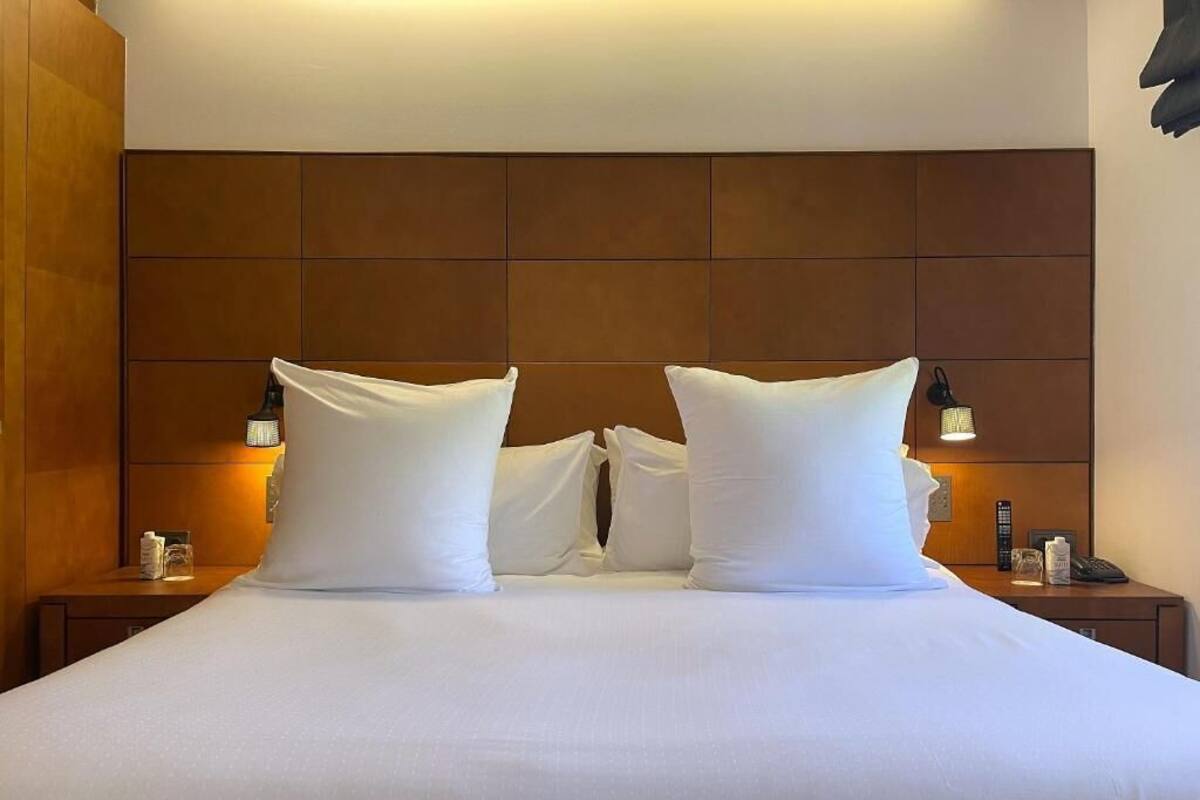 Ein Hotelzimmer mit einem großen Bett, zwei Nachttischen und einem Kopfteil.