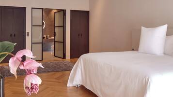 A bedroom with a large bed, a wardrobe, and a bathroom visible through an open door.
