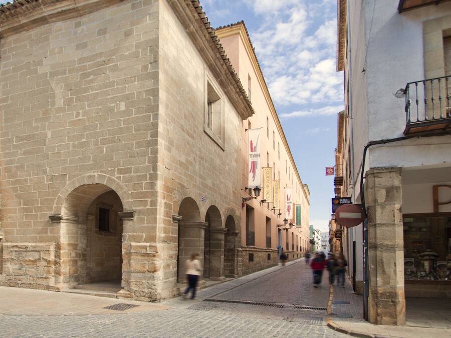 A historic stone building with arched doorways and a tiled roof.