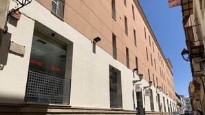 Vista de la calle con un edificio de grandes ventanales, un letrero que dice 'Calle Concepción' y un cartel de 'TRM'.