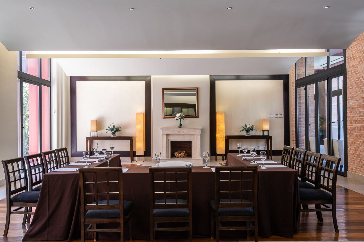 A dining area with a long table, multiple chairs, and a fireplace.