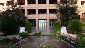 A courtyard with a central water feature, surrounded by a variety of plants and flowers. - Intelier Airén Hotel by Intelier Hotels & Suites (Alcazar de San Juan)