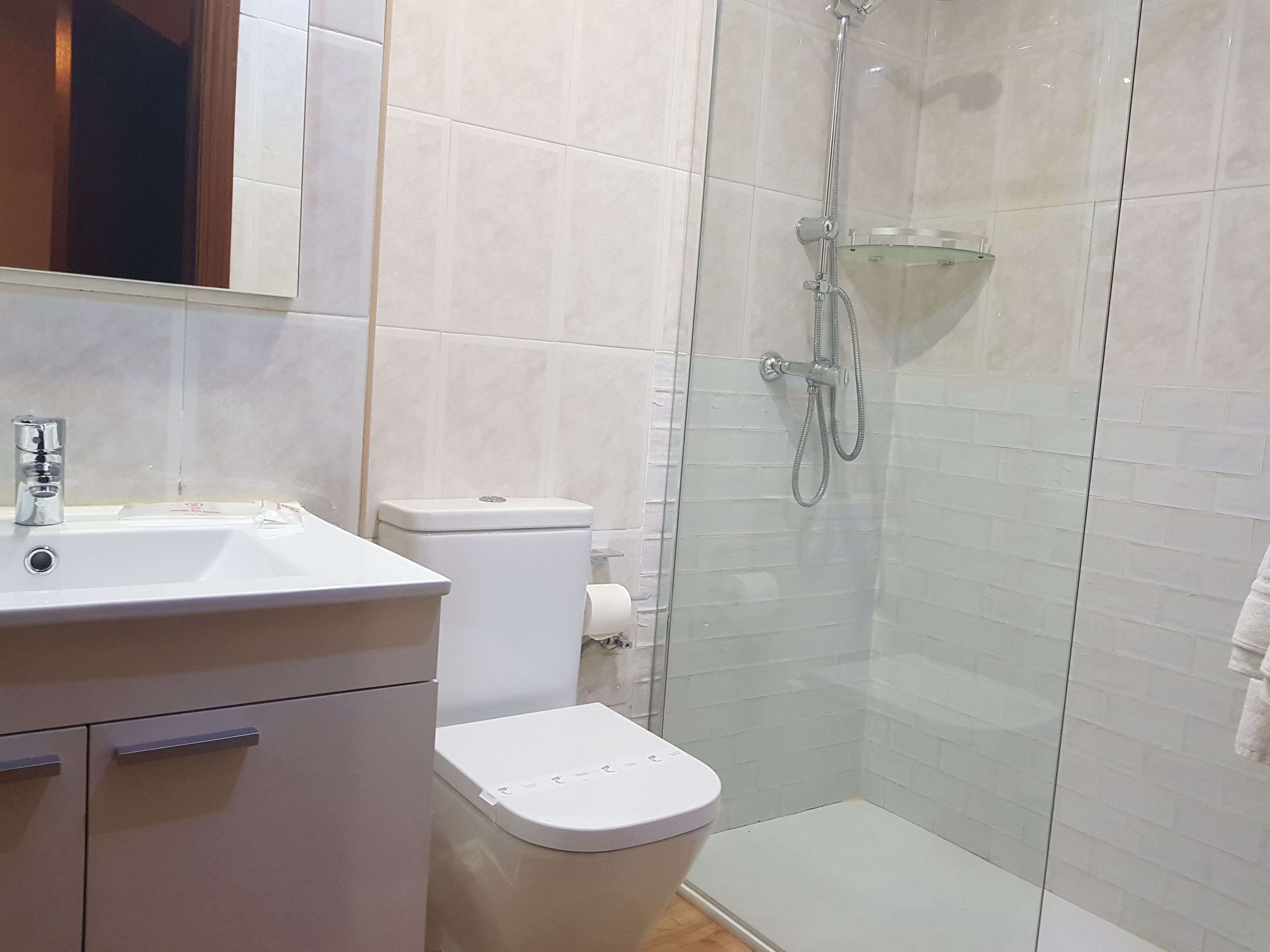 A bathroom with a toilet, sink, and shower.