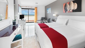Ein Hotelzimmer mit Bett, Schreibtisch, Stuhl und Meerblick.