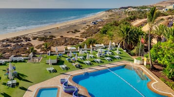Una piscina al aire libre, una piscina de entrenamiento, sombrillas