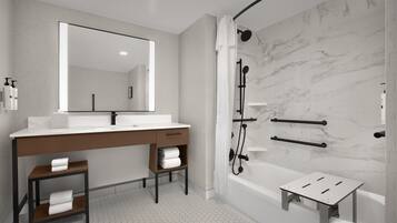 Une salle de bain moderne avec un grand miroir, deux lavabos, une douche et un petit marchepied.