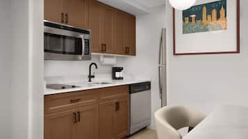 A modern kitchen with wooden cabinets, stainless steel appliances, and a white countertop.