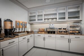 A modern kitchen with white cabinets, a coffee station, and a glass display case. - Homewood Suites by Hilton Cleveland-Solon (Solon)