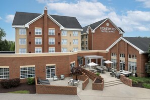 A hotel with a brick facade, outdoor seating area, and a sign reading 'Homewood Suites by Hilton'. - Homewood Suites by Hilton Cleveland-Solon (Solon)