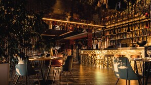 A bar area with a high ceiling, shelves with bottles, and a patterned wall. - Ibiza Corso Hotel (Ibiza Town)