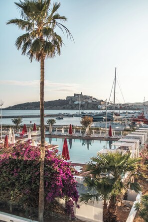 Una piscina techada, una piscina al aire libre de temporada, sombrillas