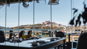 Un restaurante con vista a un pueblo costero y su puerto.