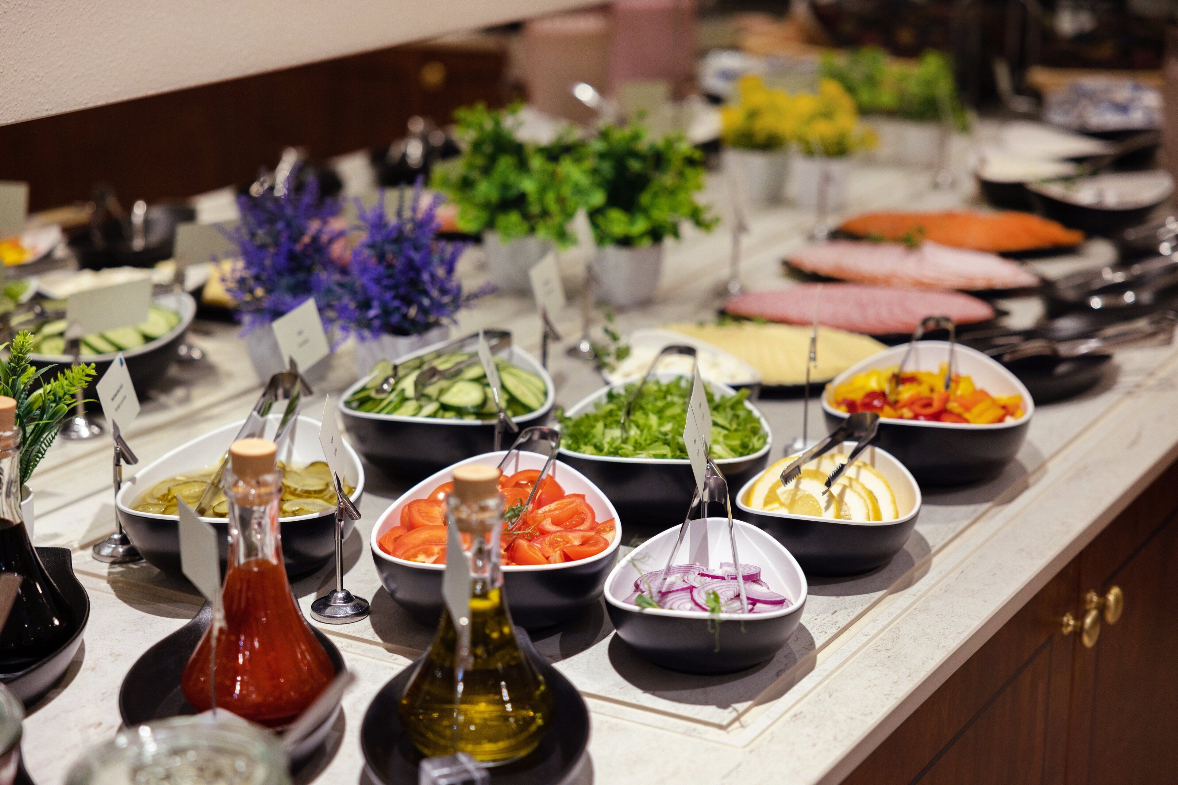 A buffet with various food options and condiments.