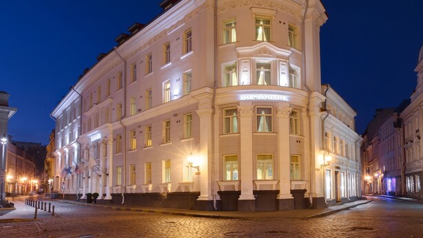 A historic building with a corner entrance, large windows, and a prominent sign. - My City Hotel (Tallinn)