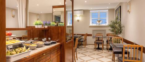 A dining area with a buffet, wooden furniture, and a tiled floor.