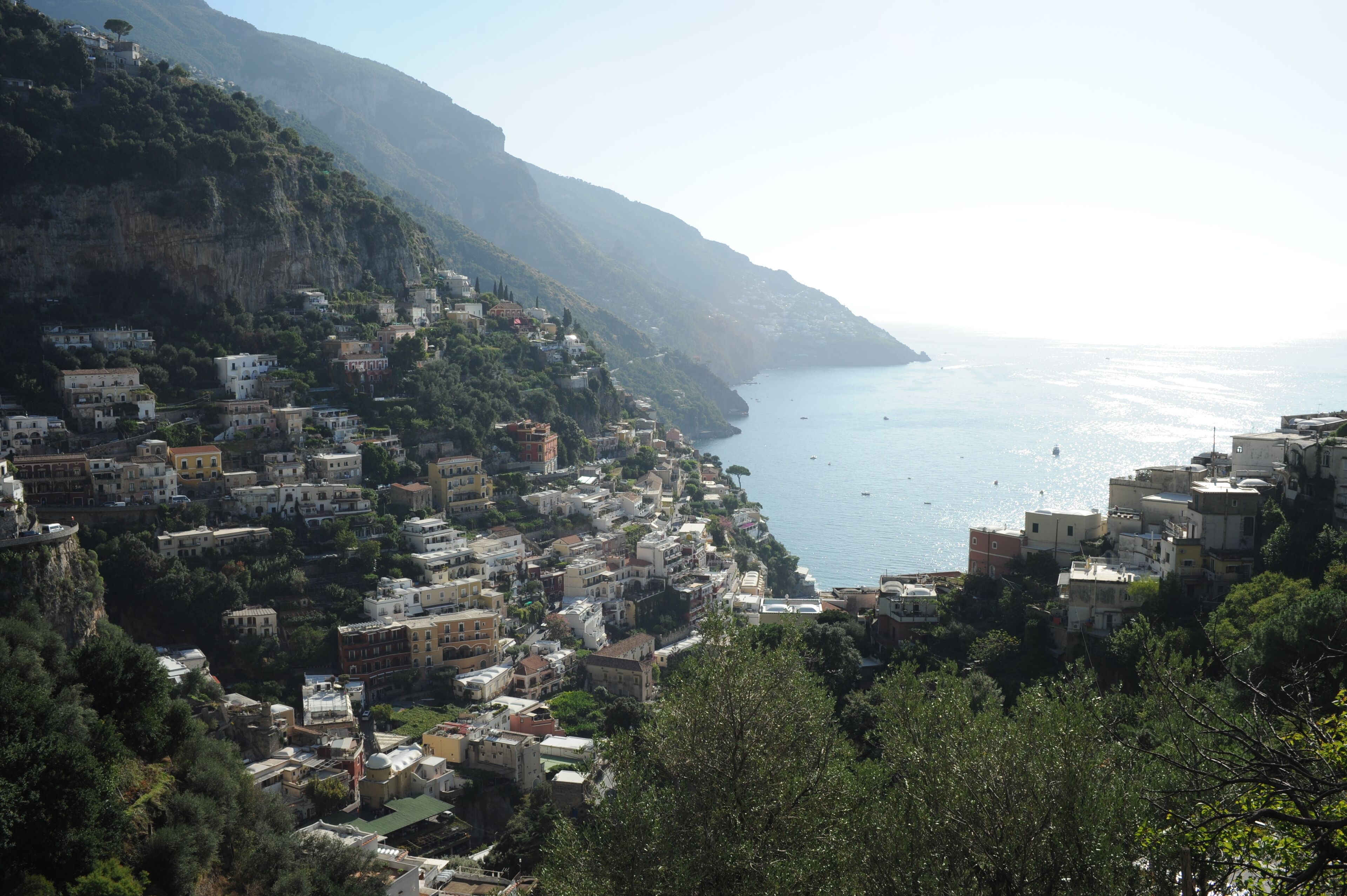 Un pueblo costero con edificios ubicados en una ladera, con vista al mar.