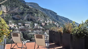 Una terrazza con due sedie e vista su un villaggio collinare.
