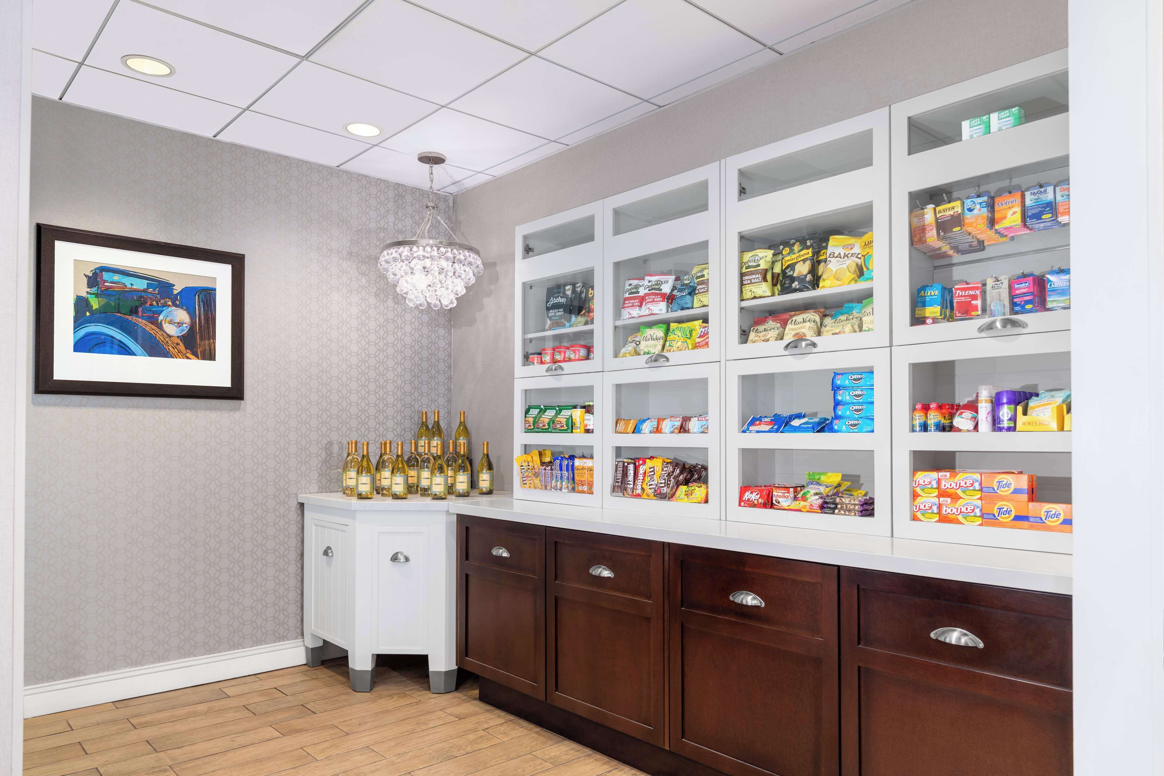 A kitchen with white cabinets, a wine rack, and a chandelier.