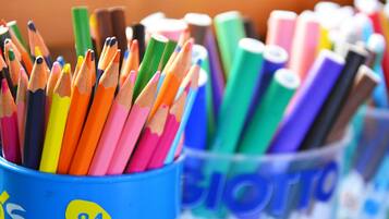 Une vue rapprochée d’un récipient rempli de crayons de couleur et de feutres de différentes couleurs.