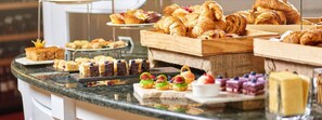 Un buffet proposant une variété de pâtisseries, de desserts et de petites portions.