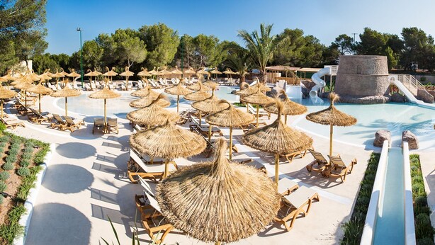 A resort pool area with multiple water slides, sun loungers, and thatched umbrellas. - Insotel Club Maryland (Formentera)