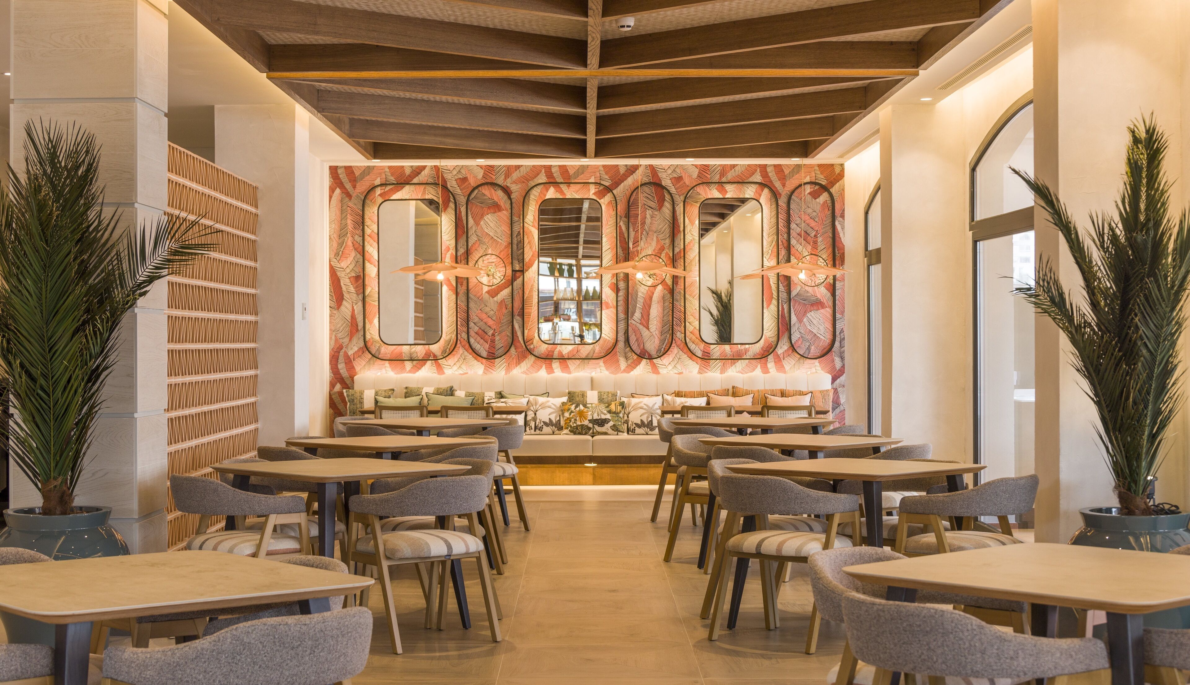 Un restaurante moderno con una zona de estar central, varias mesas y sillas.