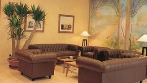 Una sala de estar con un sofá modular, una mesa de centro y una planta en maceta.