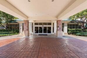 A hotel entrance with a brick pathway leading to a glass door entrance. - Hilton Garden Inn Fairfield (Fairfield)