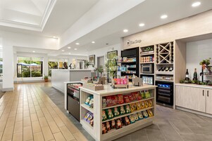 Una tienda limpia y bien iluminada, con estantes repletos de aperitivos y una sección para bebidas.