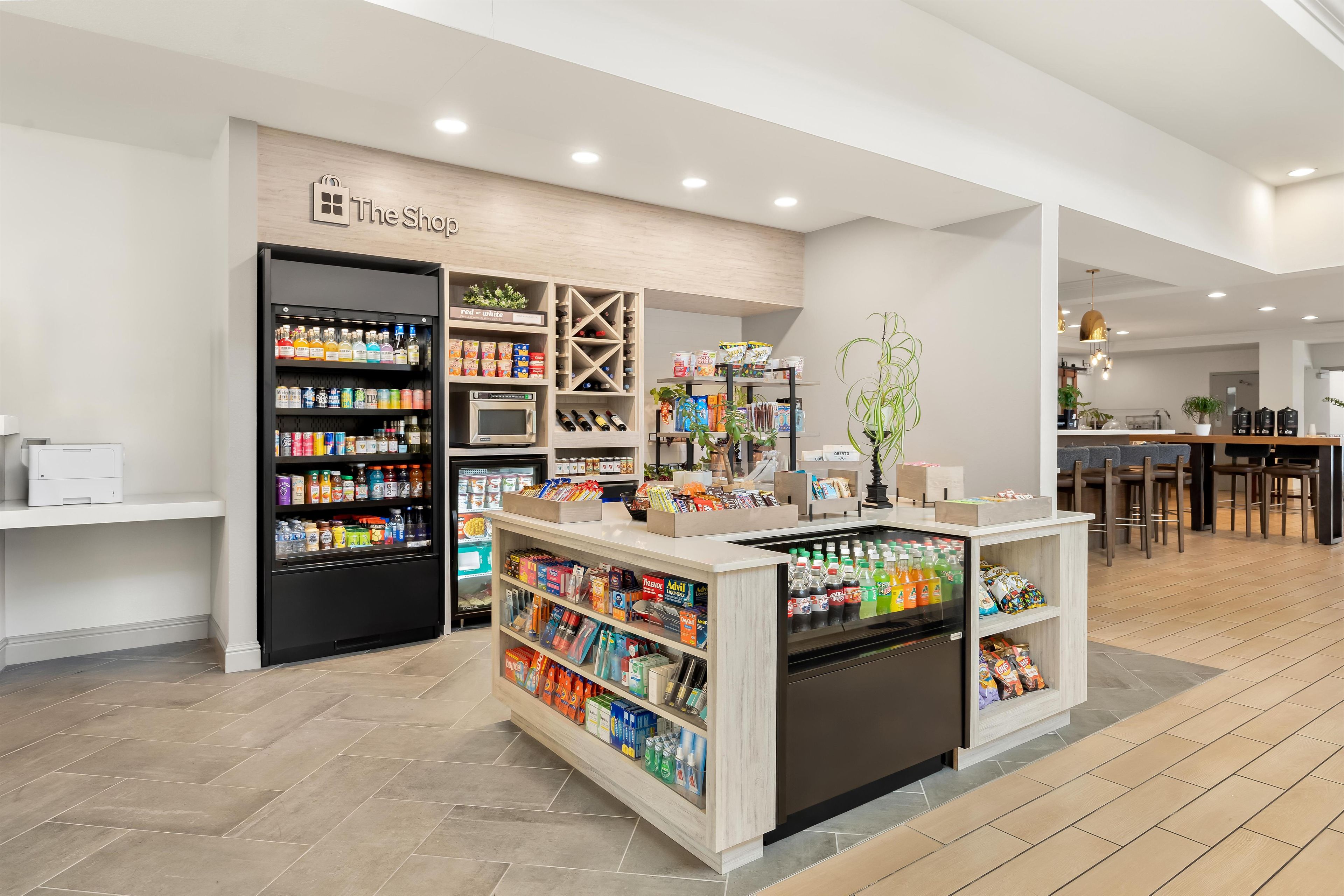 A modern retail space with a variety of products including beverages, snacks, and household items.