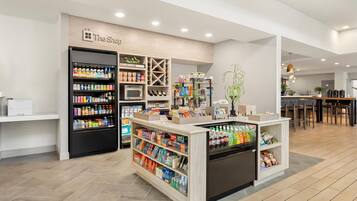 A modern retail space with a variety of products including beverages, snacks, and household items.