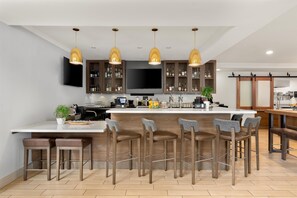 A modern kitchen with a central island, bar stools, and pendant lighting. - Hilton Garden Inn Fairfield (Fairfield)
