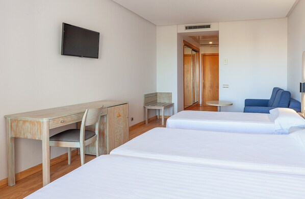 A hotel room with two beds, a desk, a chair, a TV, and a small table. - Hotel AGH Canet (Canet de Berenguer)