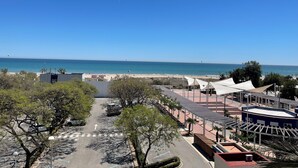 Vista costera con playa, zona de estacionamiento y edificios.
