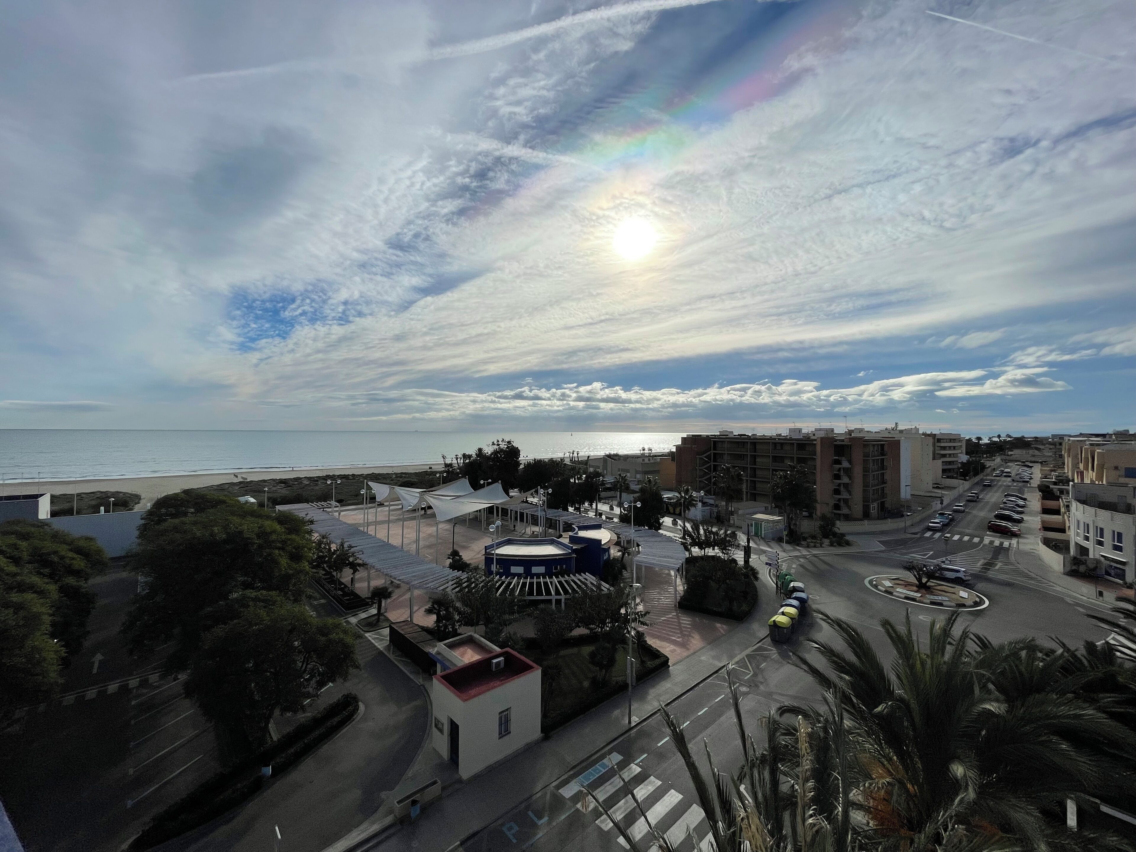 Une zone urbaine côtière dotée d’une plage, de bâtiments et d’un rond-point.