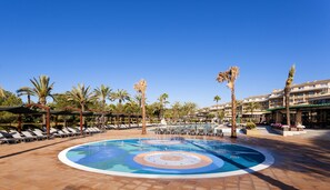 A pool area with lounge chairs, palm trees, and a building in the background. - Insotel Cala Mandía All Inclusive Resort & Spa (Manacor)