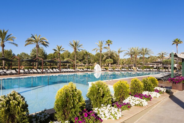 A swimming pool with lounge chairs and palm trees. - Insotel Cala Mandía All Inclusive Resort & Spa (Manacor)