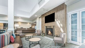 A modern living room with a fireplace, seating area, and a bar/lounge area.