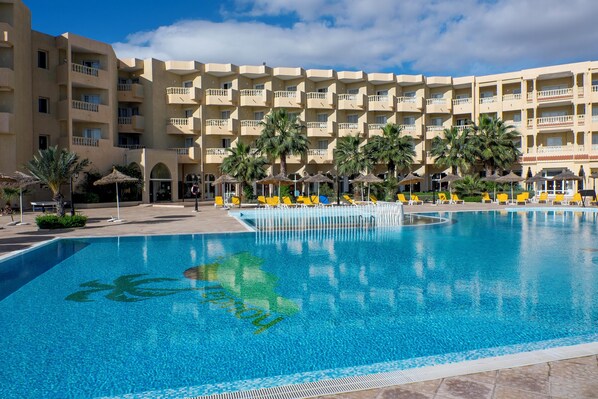 Una piscina techada, una piscina al aire libre, sombrillas