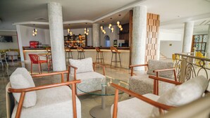 Un vestíbulo con muebles modernos, una zona de bar y una escalera.