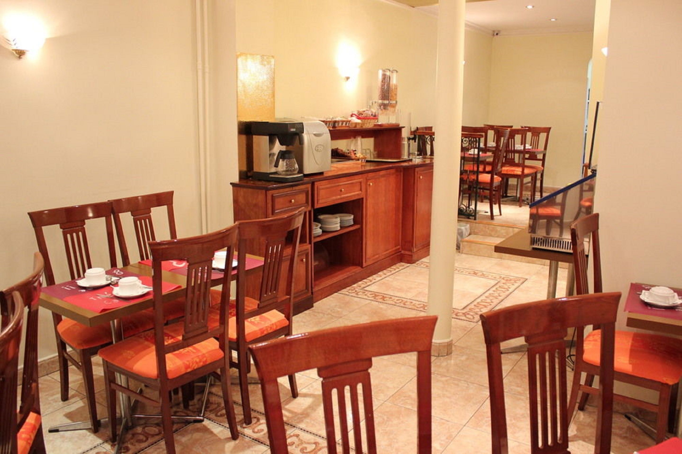 A dining area with wooden chairs and tables, a coffee machine, and a buffet counter.